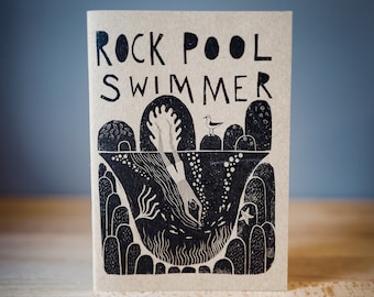 May include: A brown paper book cover with black ink illustrations of a person diving into a rock pool with a seagull perched on a rock. The title of the book is "Rock Pool Swimmer".