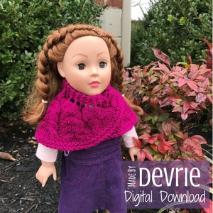 May include: A pink knitted doll-sized cape with a cable knit pattern. The cape is worn by a doll with brown hair and a purple dress. The image includes the text "Made by Devrie Digital Download".