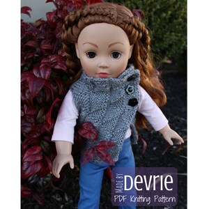 K&ouml;nnte beinhalten: Eine graue Strickweste mit hohem Kragen und Knopfverschluss. Die Weste wird von einer Puppe mit langen braunen Haaren getragen. Die Puppe tr&auml;gt eine blaue Jeans und ein wei&szlig;es Hemd. Die Weste ist mit einem strukturierten Stichmuster gearbeitet.