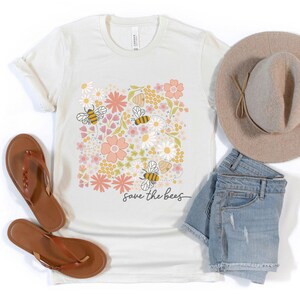 May include: A white t-shirt with a floral design featuring bees and the text "save the bees".