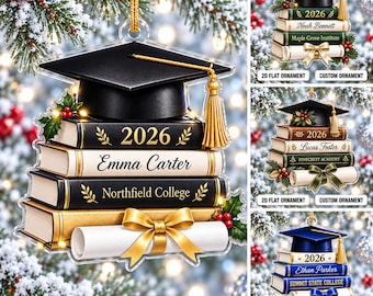 May include: A 2D flat graduation ornament featuring a black mortarboard with a gold tassel atop a stack of books. The books display the year 2026, a name, and a college name, accented with a gold ribbon and a white diploma scroll.