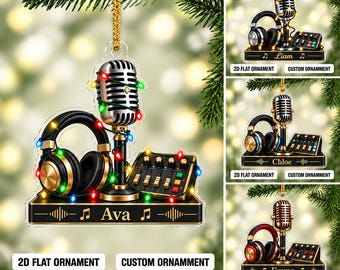 May include: A flat 2D hanging ornament featuring a silver vintage-style microphone, black headphones, and a mixing console on a black base. The design is wrapped in colorful string lights and includes the name Ava with musical note icons.