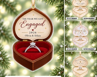 May include: A heart-shaped 2D flat ornament featuring a brown wooden box design with a red velvet interior holding a diamond ring. The text reads THE YEAR WE GOT Engaged 2026 Olivia & Ethan. It hangs from a gold ribbon for holiday display.
