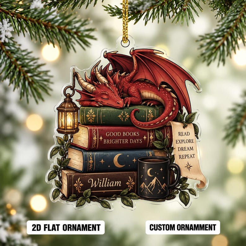 May include: A flat acrylic ornament featuring a red dragon sleeping on a stack of four books. The books are labeled with the text GOOD BOOKS BRIGHTER DAYS, William, and a scroll with READ EXPLORE DREAM REPEAT. A lantern and a mug are included.