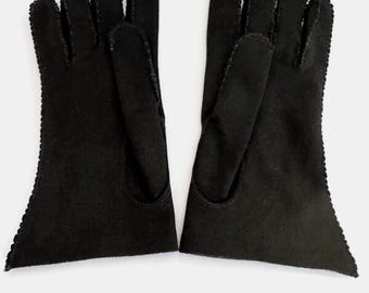 Pode incluir: Um par de luvas pretas com uma borda ondulada. As luvas são feitas de um material macio e têm um design clássico. As luvas são mostradas em um fundo branco.