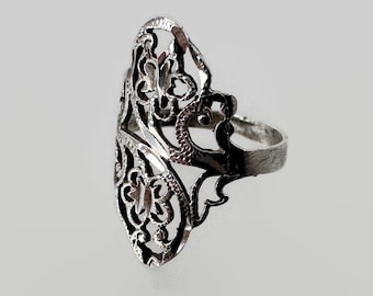 May include: A silver ring with a delicate, intricate floral design. The ring is made of a thin metal and has a wide band.