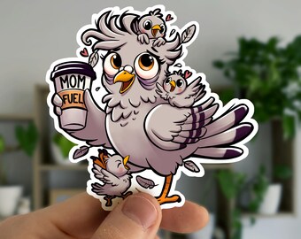 Puede incluir: Una pegatina con una paloma de dibujos animados con dos pajaritos. La paloma sostiene una taza de café que dice "MOM FUEL". La paloma es gris con detalles morados y patas naranjas. Los pajaritos son grises y blancos. La pegatina tiene un borde blanco.
