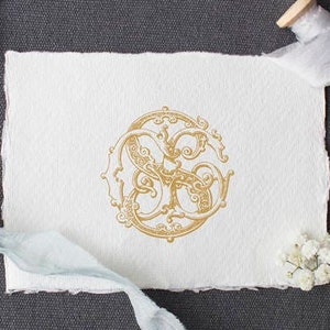 May include: A gold monogram with the letters "S" and "S" intertwined in a decorative, ornate design. The monogram is printed on a white piece of paper.