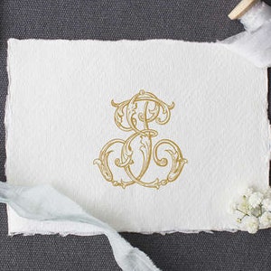 May include: A gold monogram with the letters "S" and "F" intertwined in a decorative floral design. The monogram is on a white piece of paper.