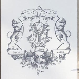 Puede incluir: Una ilustración en blanco y negro de un escudo de armas con las letras "DY" en una fuente decorativa. El escudo de armas está rodeado de diseños florales y dos animales estilizados. El texto "Diana Yates Est. 2025" está incluido en el diseño.