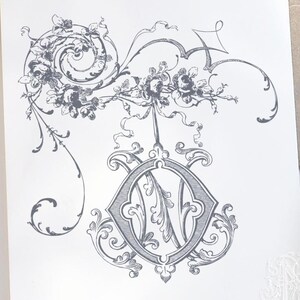 Puede incluir: Una ilustración en blanco y negro de un monograma decorativo con la letra "O" en el centro. El monograma está rodeado de diseños florales y remolinos ornamentados.