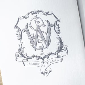 May include: A black and white illustration of a wedding monogram featuring the letters "S" and "W" intertwined. The monogram is enclosed within a decorative frame and a banner inscribed with the text "Sharon & William 2025".