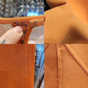 May include: Close-up of a bright orange fabric with a zip and stitching details. The fabric has a subtle texture.