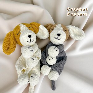 Puede incluir: Dos juguetes para perros de ganchillo, uno amarillo y blanco, el otro gris y blanco. Los perros tienen los ojos cerrados y caras sonrientes. El texto "Crochet Pattern" está en la esquina superior derecha.