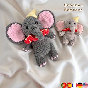 Puede incluir: Dos juguetes de elefante de ganchillo. El elefante más grande es gris con orejas forradas de rosa, una bufanda roja y blanca y un sombrero amarillo. El elefante más pequeño tiene las mismas características. El texto "Crochet Pattern" está en la esquina superior derecha.