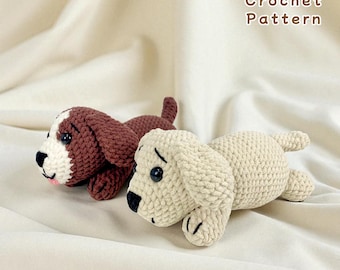 May include: Two crocheted dog toys, one brown and white, the other cream-colored, lie side-by-side on a cream-colored fabric. The brown dog has a white face and ears. The cream-colored dog has black eyes and nose. The text "Crochet Pattern" is in the upper right corner.