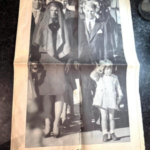 Pode incluir: Uma página de jornal a preto e branco com o título "JOHN F. KENNEDY JR. HIS LIFE REMEMBERED". A imagem apresenta uma fotografia de pessoas em trajes formais. O jornal é datado de domingo, 18 de julho de 1999, e é uma secção especial do Star-Telegram.