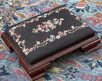 Taburete vintage bordado, estampado floral negro, base de madera de cerezo, decoración estilo cottagecore.