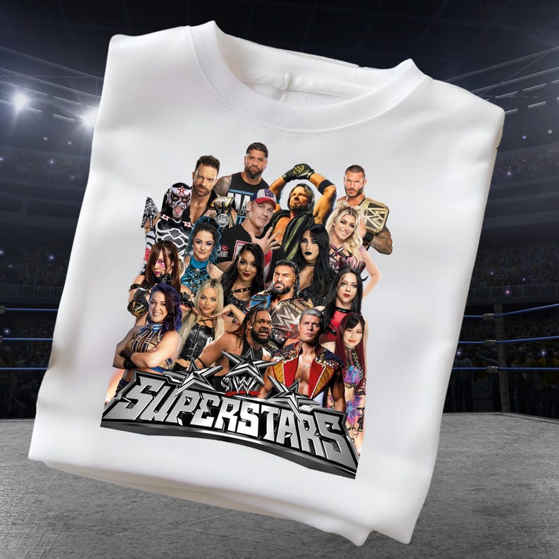 May include: White crew neck sweatshirt featuring a graphic of multiple wrestling superstars. The graphic includes the text "SUPERSTARS" in silver and black. The sweatshirt is made of a soft material.
