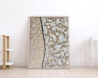 May include: Framed abstract artwork with a light wood frame. The artwork features a textured design with gold and white elements, a black vertical line, and ornate gold patterns. The piece is displayed against a white wall.