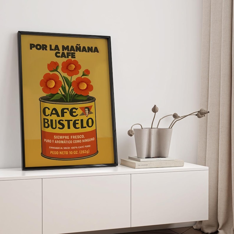 Pode incluir: P&ocirc;ster emoldurado com um an&uacute;ncio vintage de caf&eacute; Cafe Bustelo. O p&ocirc;ster tem um fundo amarelo com as palavras "POR LA MA&Ntilde;ANA CAFE" no topo. Um gr&aacute;fico de lata de caf&eacute; com flores vermelhas est&aacute; no centro. A lata diz "CAFE BUSTELO" e "PESO NETO 283g".