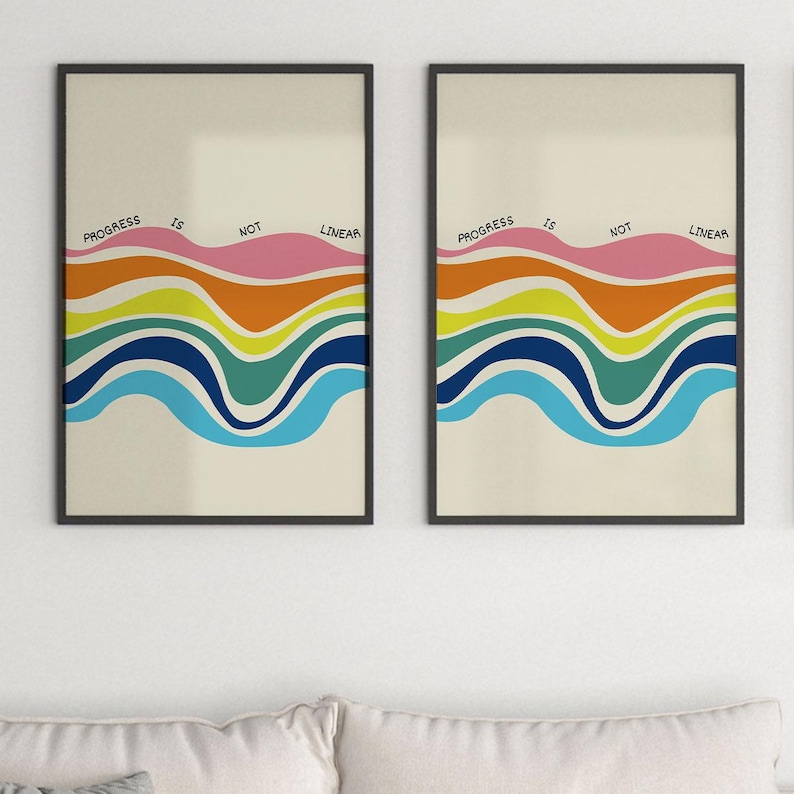 May include: Two framed art prints with a cream background. Each print features a colorful, wavy design in shades of blue, green, yellow, orange, and pink. The text "PROGRESS IS NOT LINEAR" is arched across the top of each print.