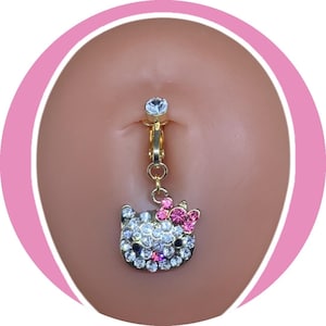 May include: Gold-toned belly button ring featuring a sparkling Hello Kitty charm. The charm is encrusted with clear and pink rhinestones, and a pink bow. The top of the ring has a clear, round gem.