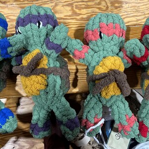 May include: Four plush turtle toys in different colors. The turtles are green with brown shells and have different colored bandanas. The turtles are made of soft, fuzzy material and are perfect for playing fetch or cuddling.