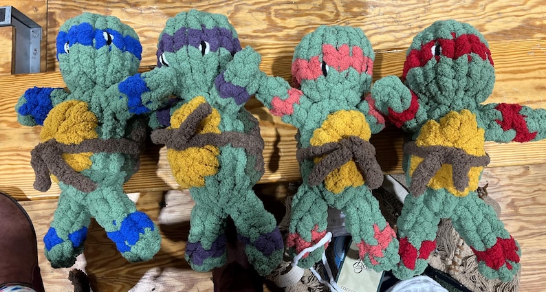 May include: Four plush turtle toys in different colors. The turtles are green with brown shells and have different colored bandanas. The turtles are made of soft, fuzzy material and are perfect for playing fetch or cuddling.