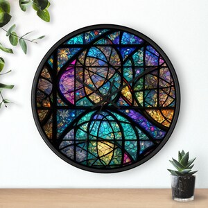 Pode incluir: Relógio de parede redondo com moldura preta e design de vitral. O mostrador do relógio apresenta um padrão de mosaico colorido com tons de azul, roxo, amarelo e verde. Os ponteiros do relógio são pretos.