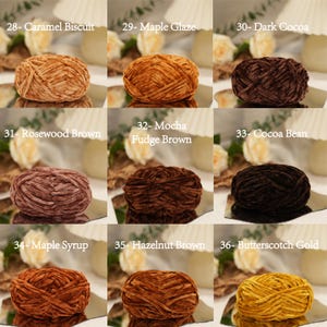 May include: Nine skeins of velvet yarn in various shades of brown and gold. Colors include Caramel Biscuit, Maple Glaze, Dark Cocoa, Rosewood Brown, Mocha Fudge Brown, Cocoa Bean, Maple Syrup, Hazelnut Brown, and Butterscotch Gold. Each skein is labeled with a number.