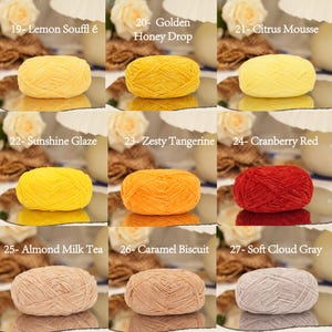 May include: Nine skeins of yarn in various colors, including yellow, orange, red, beige, and gray. Each skein is labeled with a color name, such as "Lemon Souffl&eacute;," "Golden Honey Drop," and "Cranberry Red."
