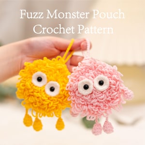Op de afbeelding: Twee gehaakte monsterzakjes, één gele en één roze, met grote ogen met witte randen en bungelende aanhangsels. De tekst "Fuzz Monster Pouch Crochet Pattern" wordt bovenaan de afbeelding weergegeven.