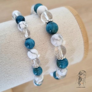 Op de afbeelding: Twee armbanden gemaakt met witte en blauwe kralen. De armbanden zijn gemaakt met witte howliet, blauwe apatiet en heldere kwarts kralen.