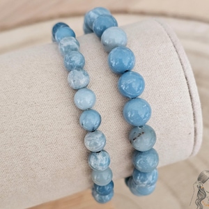 Pode incluir: Duas pulseiras de pedras azuis com contas graduadas. As pulseiras são feitas de contas azul claro, azul médio e azul escuro. As contas são redondas e lisas.