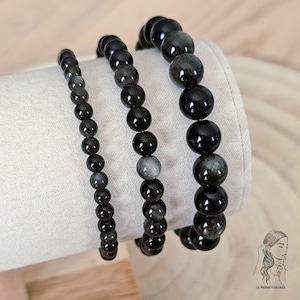 Peut inclure: Trois bracelets de perles noires de tailles variées sont présentés. Les perles ont une finition brillante et les bracelets sont disposés côte à côte, mettant en valeur leurs différentes tailles de perles et leurs designs.
