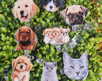May include: A set of seven colorful retractable badge holders featuring different dog and cat breeds. The holders are made of clear plastic and have a spring-loaded mechanism that allows them to extend and retract.