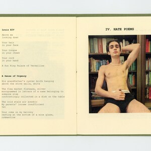 May include: A book with a green cover and a white page open to a poem titled "Hate Poems". The poem is about a man looking down at another man. The page on the right side of the book shows a photo of a man sitting in a chair with his shirt off. He is looking at the camera. There are bookshelves behind him.