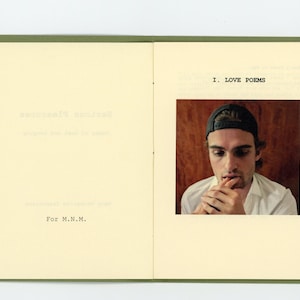 May include: A book with a green cover and a photo of a person wearing a baseball cap. The text on the page reads "I. LOVE POEMS".