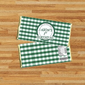 Pode incluir: Duas embalagens de barras de chocolate com um padrão xadrez verde e branco. Uma embalagem tem um rótulo circular que diz "Jason's 1st Birthday" e "Let's Par-Tee!". A outra embalagem tem um rótulo nutricional e um código de barras.