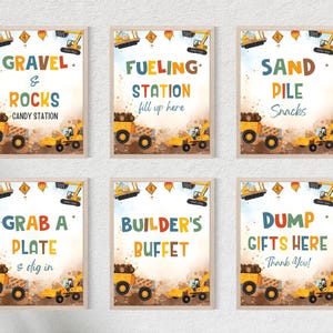 May include: Six framed construction-themed party signs. Each sign features a yellow dump truck and excavator, with text like "Gravel & Rocks Candy Station" and "Dump Gifts Here Thank You!" in colorful fonts.