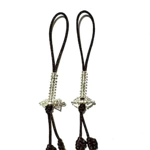 May include: Two silver-coloured charms with dark brown cords and tassels. Each charm has a coiled spring design and a loop at the top. The tassels are a darker shade of brown.