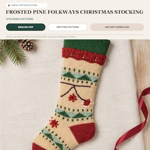 Może przedstawiać: Cyfrowy wzór dziewiarski na świąteczną skarpetę Frosted Pine Folkways. Skarpeta jest w kolorze kremowym z zielonym mankietem, czerwoną piętą i palcami oraz posiada dzianinowy wzór w zielone sosny i czerwone motywy kwiatowe.