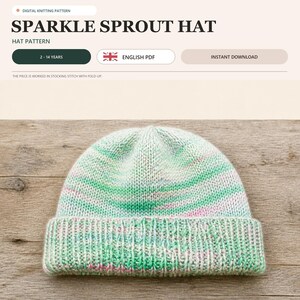 May include: A digital knitting pattern titled Sparkle Sprout Hat for ages 2-14 years in English PDF format. The image displays a knit beanie with a fold-up brim, featuring a variegated yarn color palette of soft green, white, and light pink tones.
