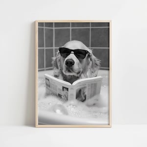 May include: A black and white photo of a golden retriever wearing sunglasses and relaxing in a bubble bath while reading a newspaper.