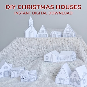 May include: A collection of white paper DIY Christmas houses, including a church and various cottages. The text "DIY CHRISTMAS HOUSES INSTANT DIGITAL DOWNLOAD" is displayed. The houses are arranged on a white, textured surface.