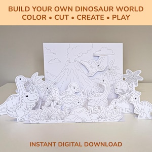 May include: A paper craft set featuring black and white line art of dinosaurs, a volcano, and palm trees for colouring. The text reads BUILD YOUR OWN DINOSAUR WORLD COLOR • CUT • CREATE • PLAY and INSTANT DIGITAL DOWNLOAD.