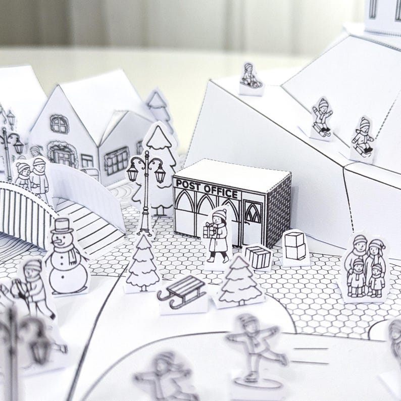 May include: A black and white papercraft winter village scene with a post office, houses, trees, and figures ice skating and walking. The post office has the words "POST OFFICE" printed on it.