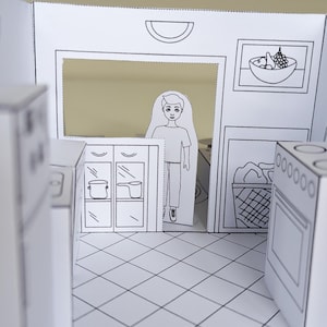 May include: A paper craft kitchen playset featuring black and white line art. The scene includes a flat cutout figure of a person, a stove, cabinets with pots, a laundry basket, and a framed bowl of fruit on the wall, all set on a tiled floor.