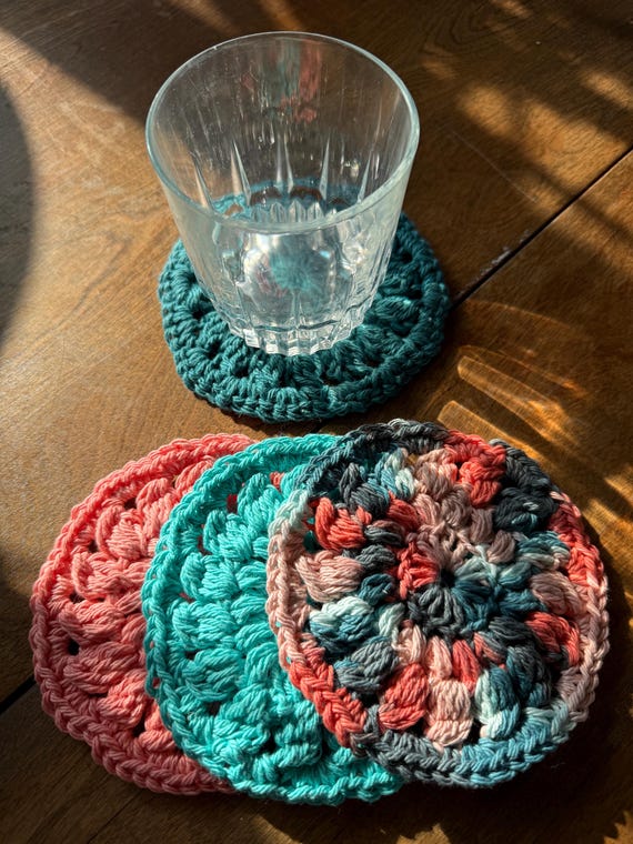 set of 4 hand crocheted cotton coasters in coral reef pink, teal and aqua